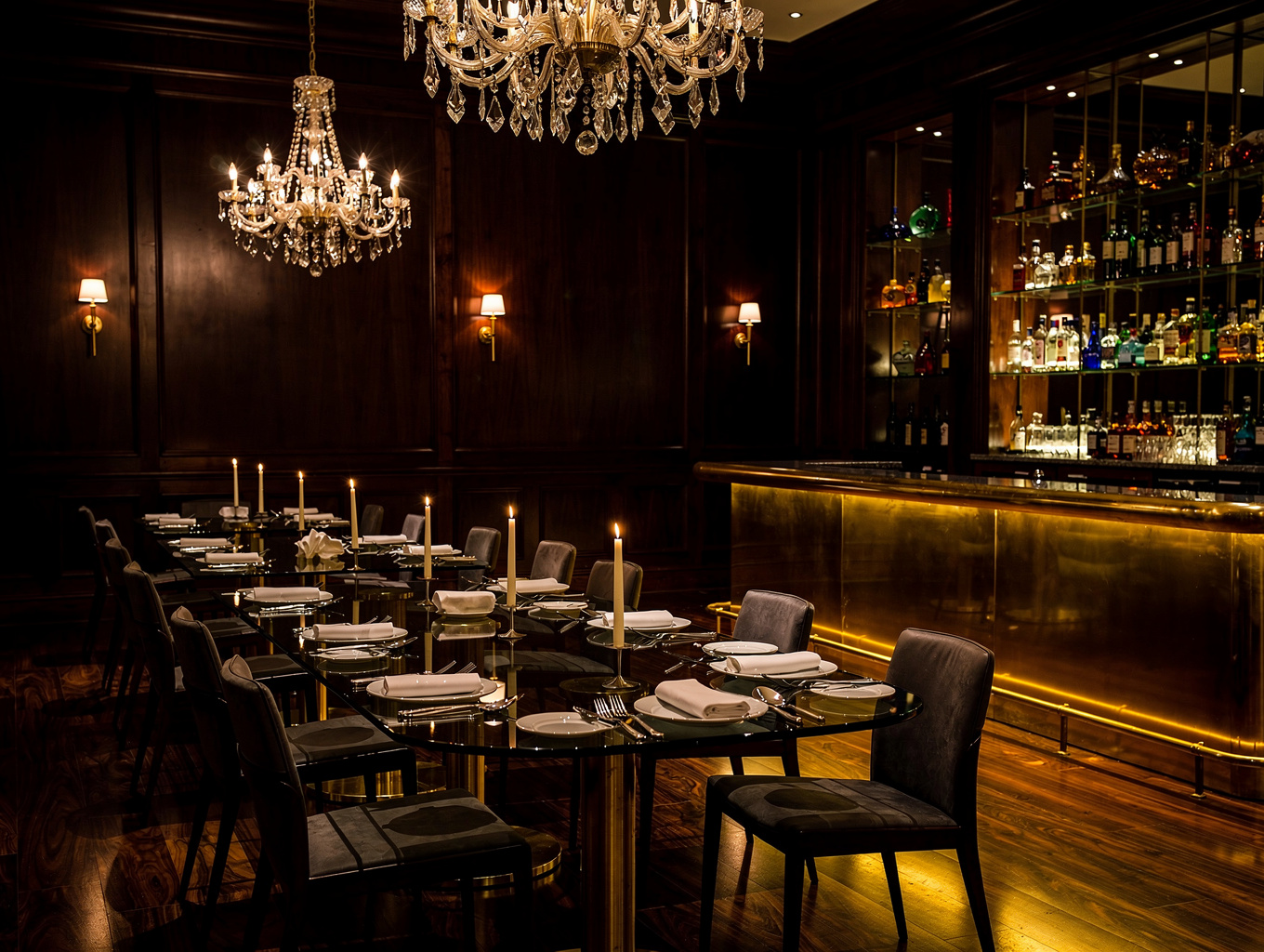 Warmly lit Indian dining room with brass accents and dark stone walls